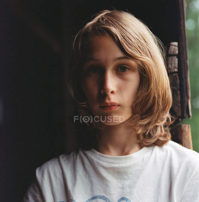 Мальчик с длинными волосами, задумчивое выражение лица — стоковое фото