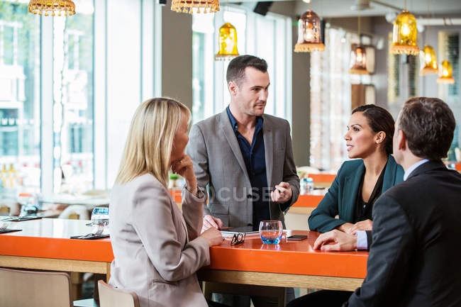 Businessman and businesswoman in discussion in cafe — Stock Photo