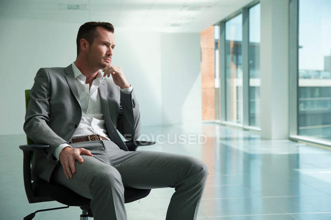 Geschäftsmann sitzt im Sessel — Stockfoto