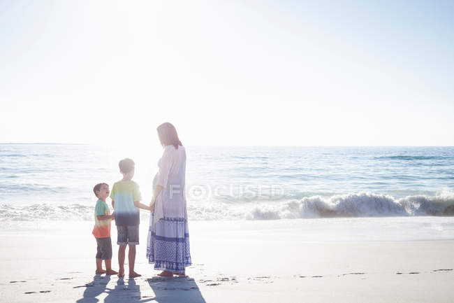 Madre e figli sulla spiaggia — Foto stock