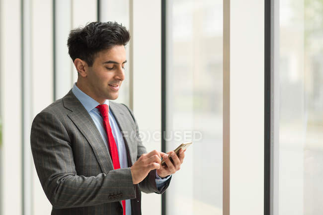 Homme d'affaires regardant à l'aide d'un écran tactile smartphone — Photo de stock