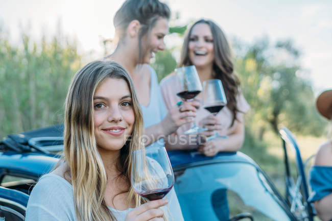 Друзья пьют вино в машине — стоковое фото
