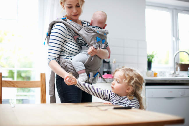 Girl helping mother lay table — Stock Photo