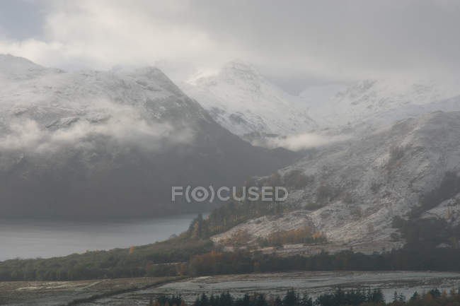 Low clouds and snow capped mountains — Stock Photo