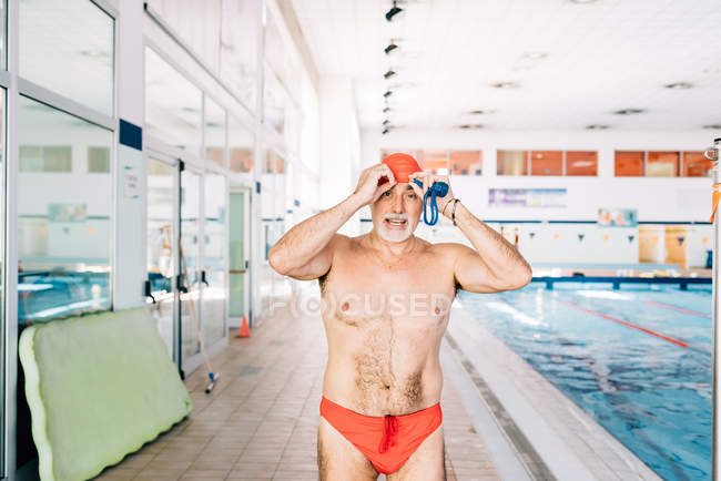 Uomo in piedi vicino alla piscina — Foto stock