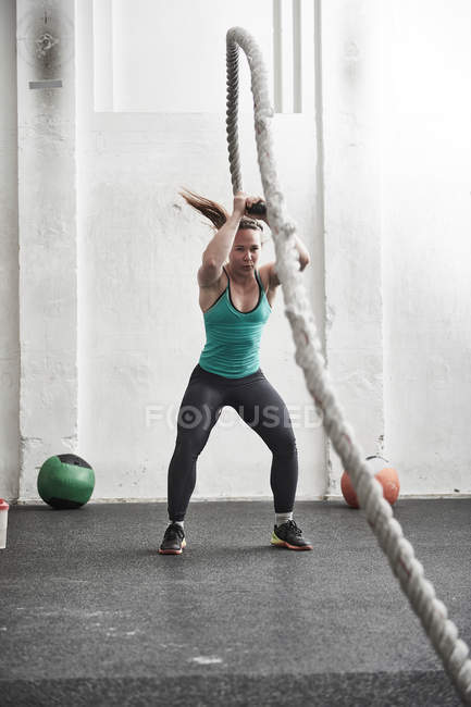 Woman working out with battle rope — Stock Photo