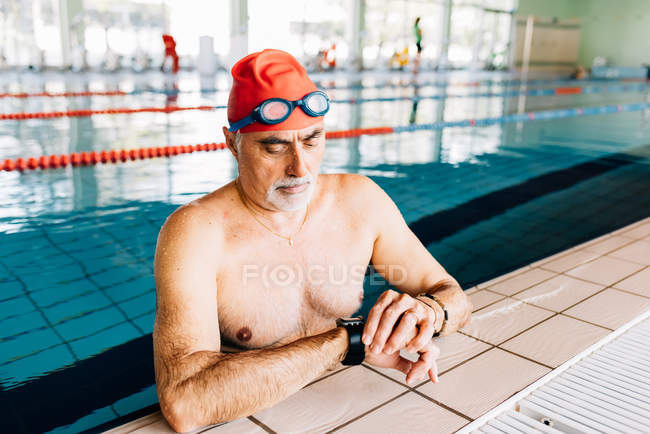 Man watching on clock in water by edge — Stock Photo
