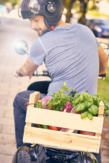 Homme à moto transportant des légumes — Photo de stock