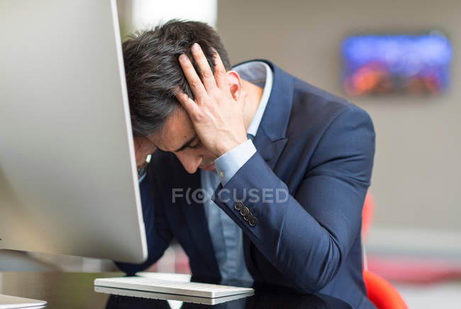 Empresario estresado en la computadora de oficina - foto de stock