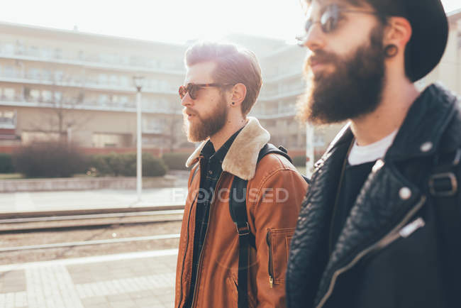 Hipster friends wearing sunglasses in city — Stock Photo