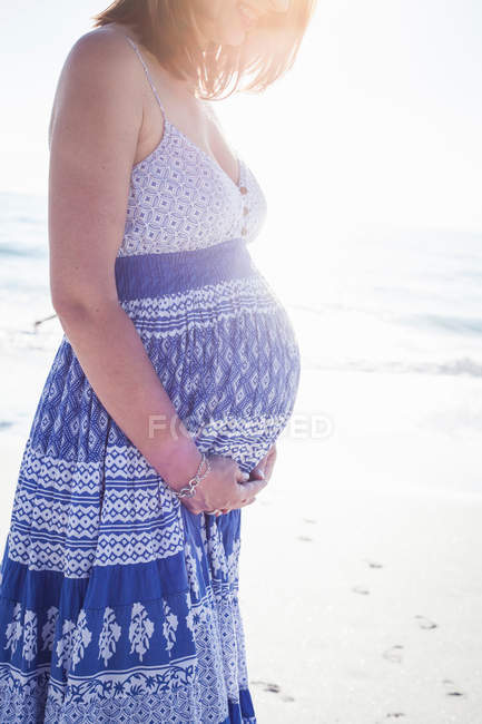 Donna incinta sulla spiaggia — Foto stock