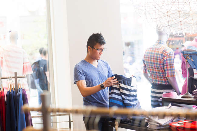 Молодий чоловік купує одяг — стокове фото