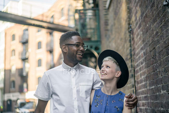 Jovem casal andando ao longo da rua — Fotografia de Stock
