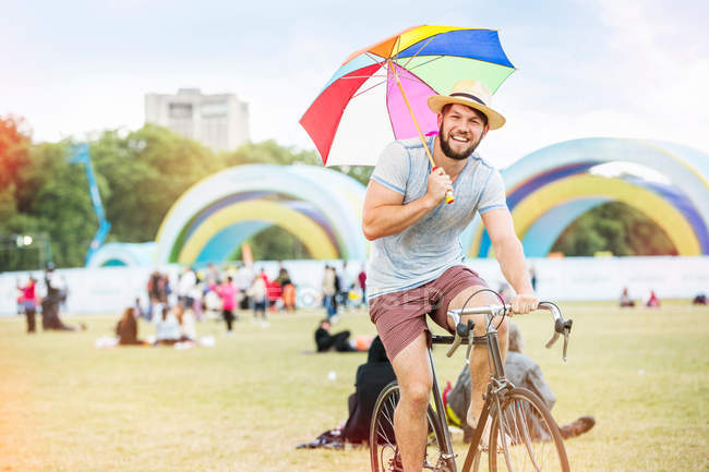 Hombre con paraguas montar en bicicleta - foto de stock