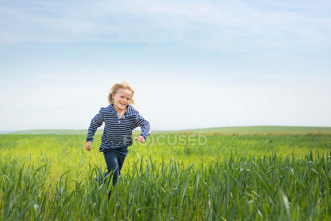 Boy running in grass — Stock Photo