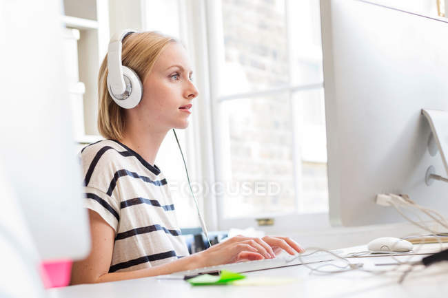 Designer listening to headphones — Stock Photo