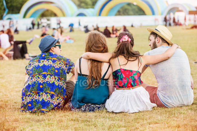 Amigos sentados en la hierba - foto de stock
