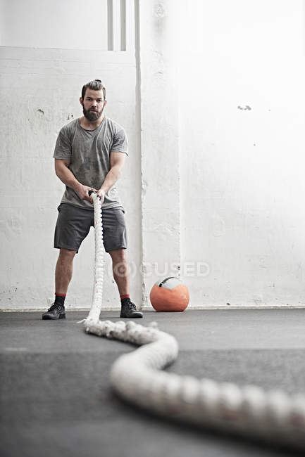Man working out with battle rope — Stock Photo