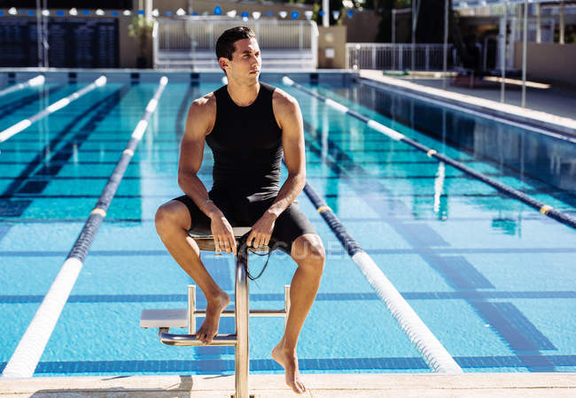 Nadador sentado al final de la piscina - foto de stock