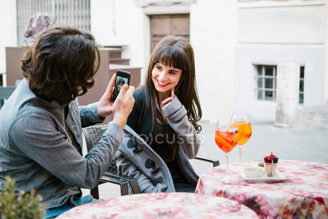 Jovem casal sentado fora do café — Fotografia de Stock