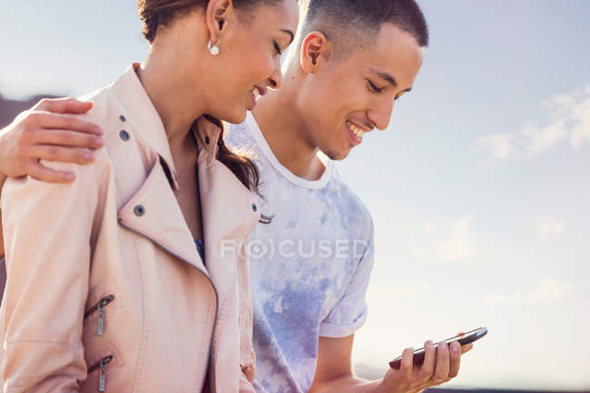 Paar schaut aufs Smartphone — Stockfoto