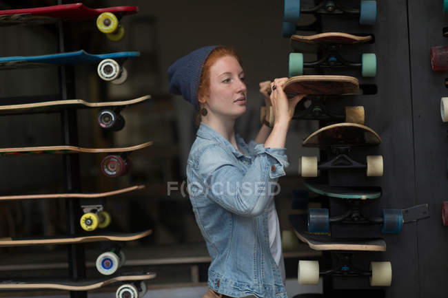 Женщина работает в магазине скейтбордов — стоковое фото
