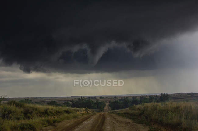 Rotating funnel cloud over rural road — Stock Photo