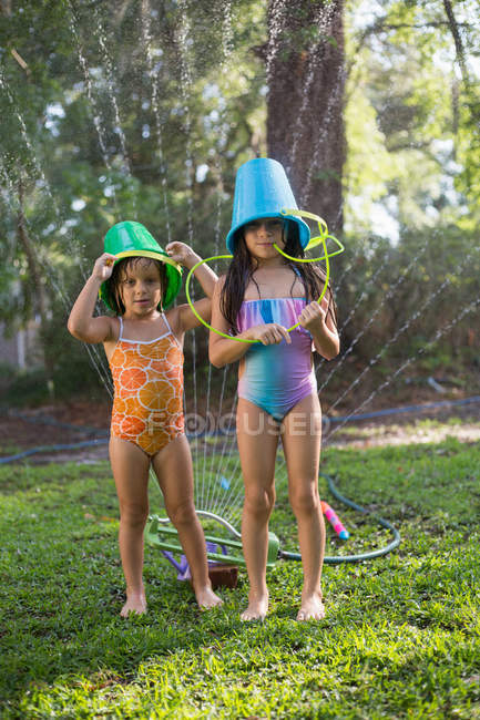 Девушки с ведрами на голове — стоковое фото