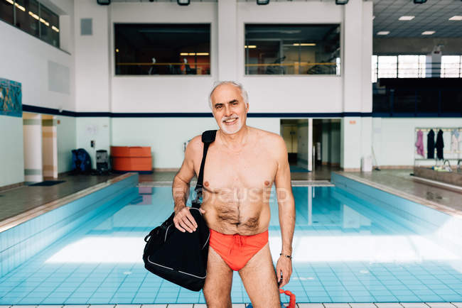Uomo che trasporta borsa in piscina — Foto stock