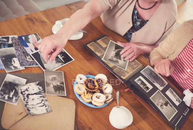 Senior women looking at old photographs — Stock Photo