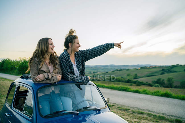 Туристы, стоящие на крыше автомобиля — стоковое фото