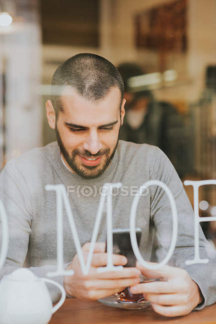 Молодой человек сидит в кафе — стоковое фото