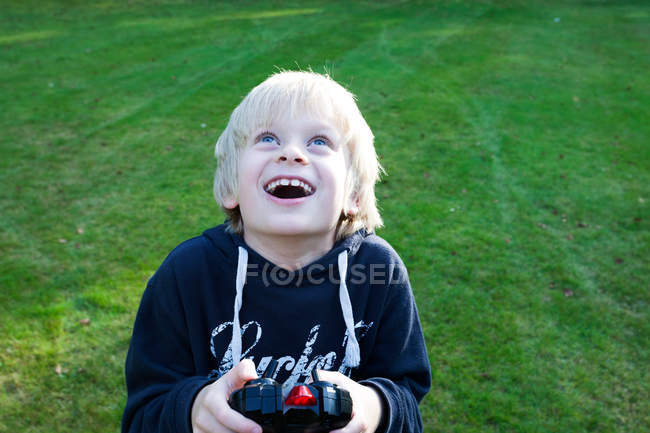 Niño sosteniendo control remoto - foto de stock