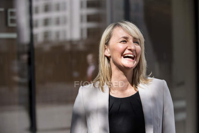 Femme d'affaires devant le bâtiment en verre — Photo de stock