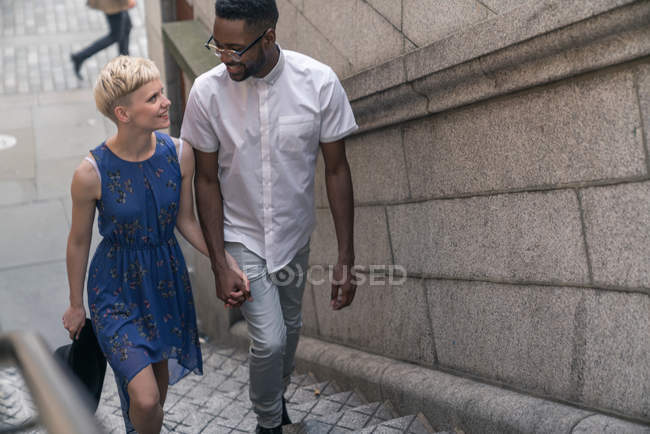 Jeune couple marchant sur les marches — Photo de stock