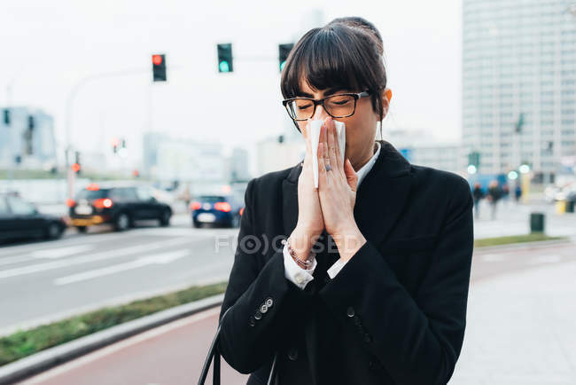 Businesswoman blowing nose — Stock Photo
