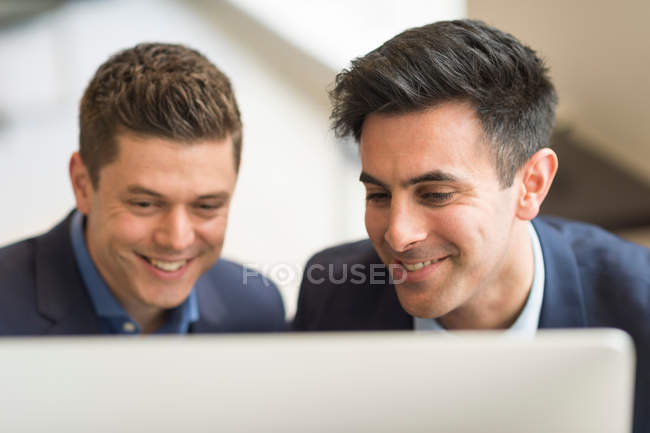 Бізнесмени дивляться на комп'ютер в офісі — стокове фото