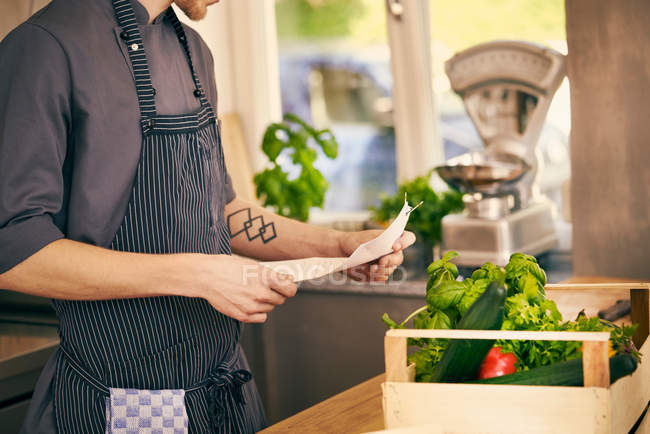 Chef checking delivery note — Stock Photo