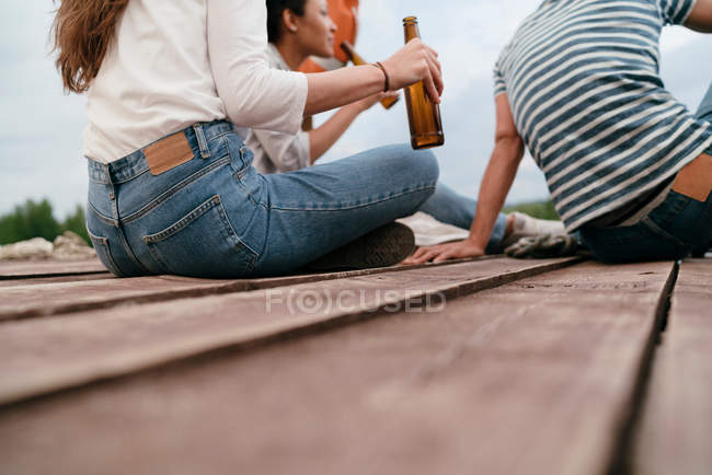 Amigos sosteniendo botellas de cerveza - foto de stock