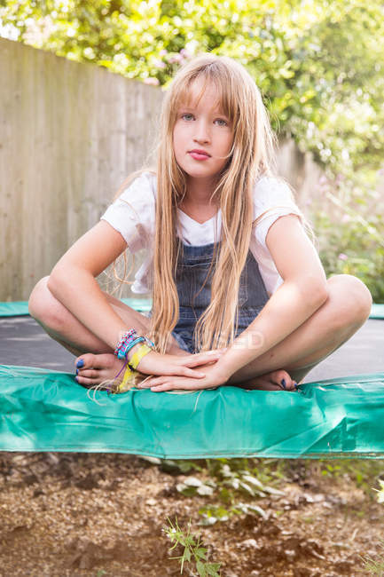 Mädchen sitzt auf Trampolin — Stockfoto