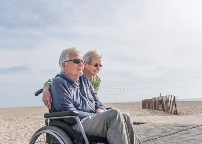 Hombre en silla de ruedas con esposa - foto de stock