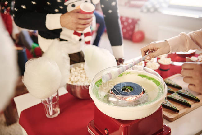Cropped shot of young woman preparing candyfloss at christmas party — Stock Photo
