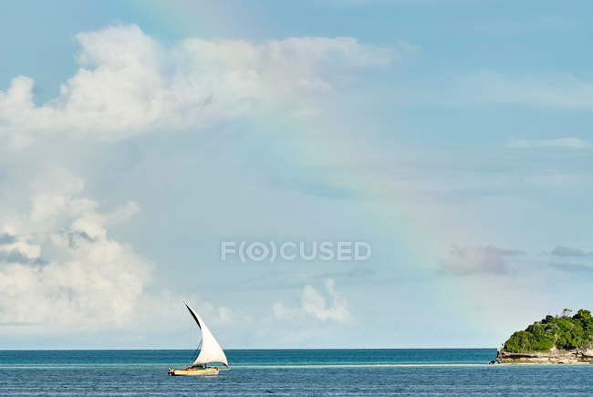 Yacht in sea under rainbow — Stock Photo