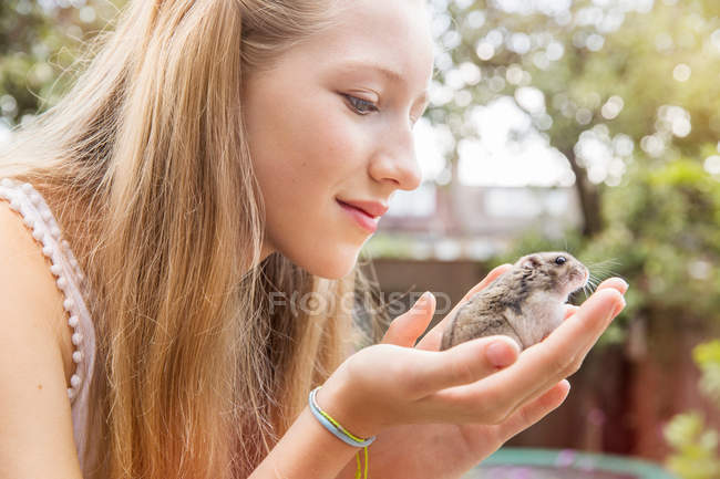 Девочка-подросток держит хомячка — стоковое фото