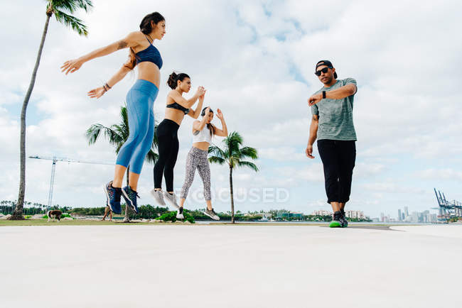 Three women working out with trainer — Stock Photo