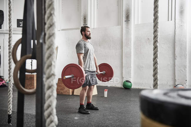 Man lifting barbell — Stock Photo