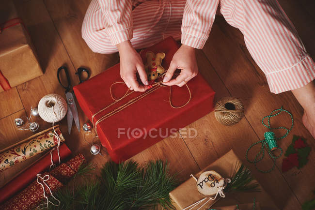Donna che avvolge regalo di Natale con spago — Foto stock