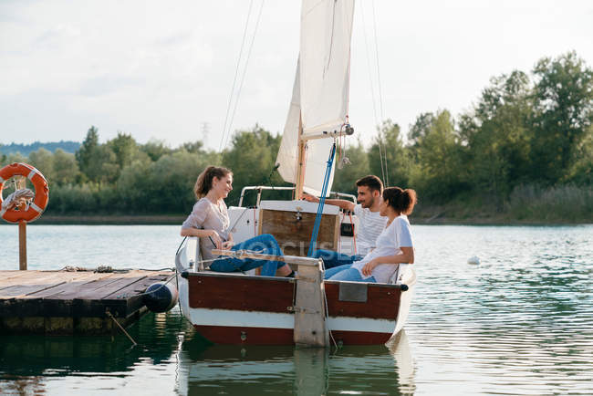 Tre amici si rilassano in barca a vela — Foto stock