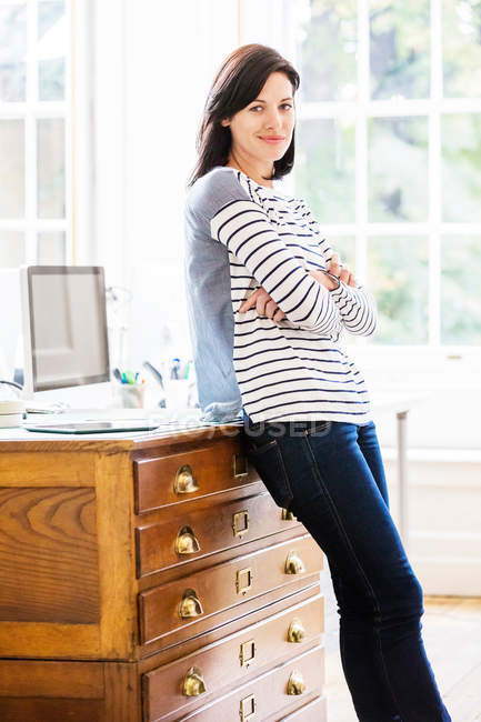 Diseñadora femenina apoyada en cajones - foto de stock