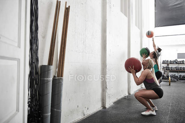 Amigos lanzando bolas de fitness - foto de stock